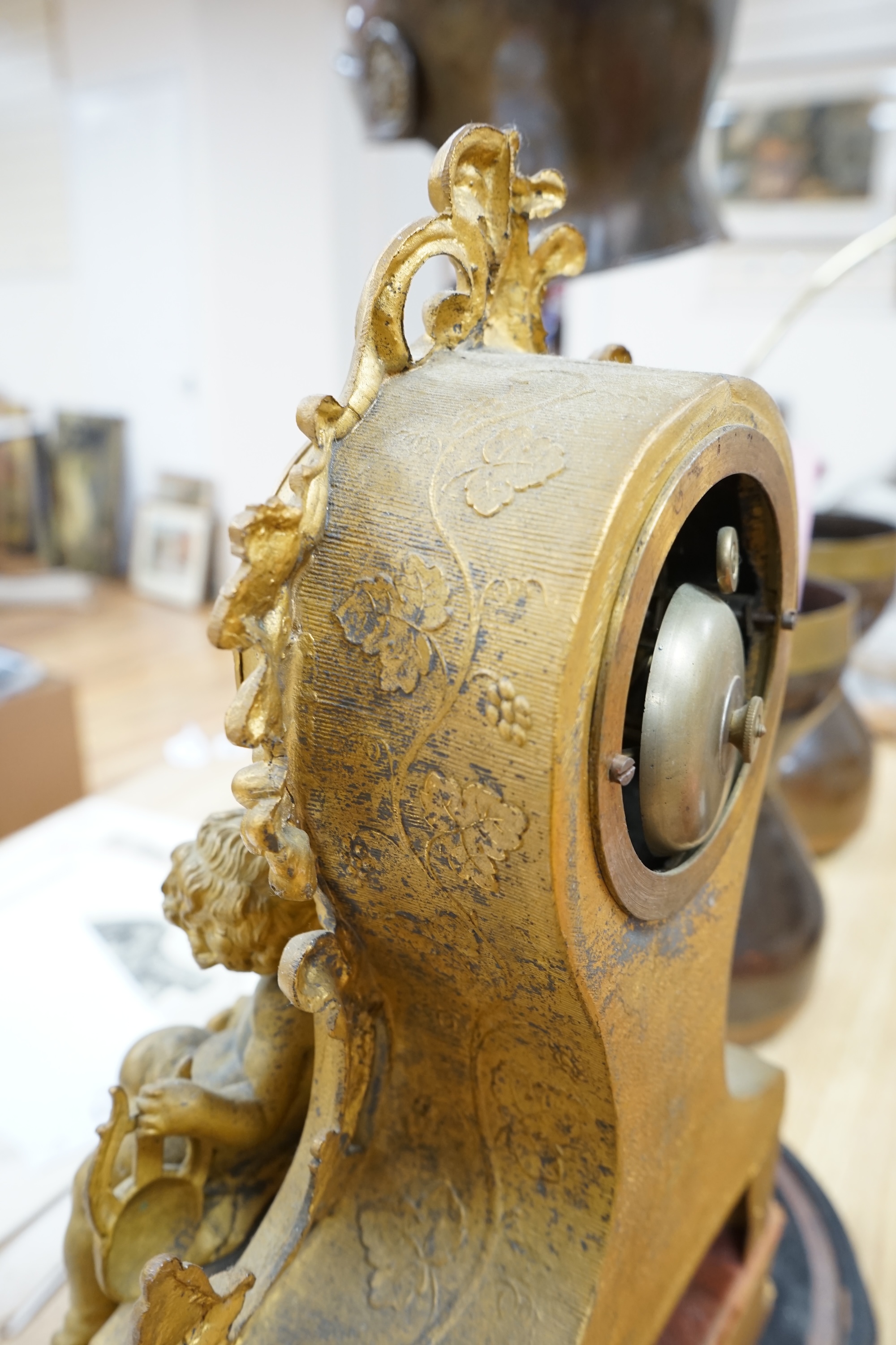 A 19th century French, Rococo Revival gilt metal figural mantel clock, striking on a bell, raised on gilt wood plinth, no key, 41cm high. Condition - fair, untested